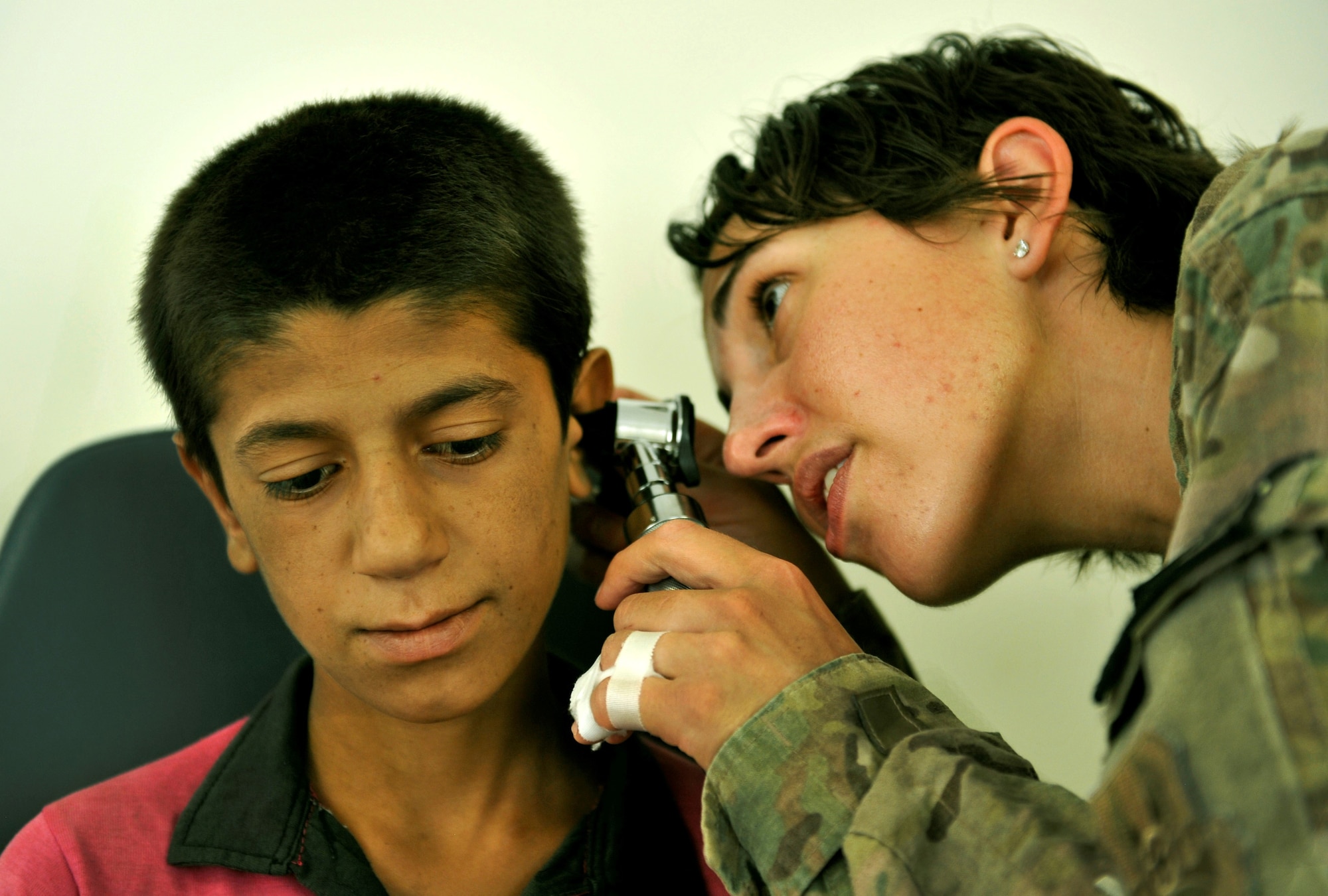 Major Jamie Swartz, an ear nose and throat surgeon, and her assistant, Staff Sgt. Robyn Wilcox, remove ear wax and examine an eight-year-old patient’s ear for an infection during a follow-up appointment at the Korean humanitarian Hospital on Bagram Airfield, Afghanistan, July 30, 2013. The boy recently had a surgery performed on his ear to remove an infection from the middle ear. (U.S. Air Force photo/Staff Sgt. Stephenie Wade)
