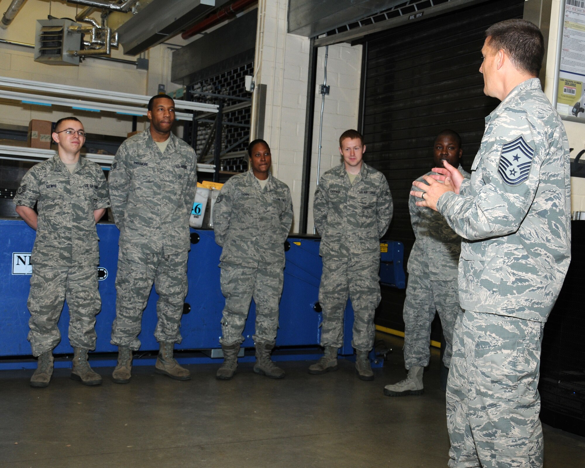 From right, U.S. Air Force Chief Master Sgt. Tracy Jones, 100th Air Refueling Wing command chief, speaks to Airmen from the post office after assisting the Airmen in unloading and sorting the mail Aug. 8, 2013, on RAF Mildenhall, England. The “dirty jobs” program provides leadership the opportunity to visit different units on base to see how they contribute to the wing’s mission. As part of the program, Jones has also visited other squadrons, including the 100th Civil Engineer Squadron, 100th Logistics Readiness Squadron and 100th Security Forces Squadron. (U.S. Air Force photo by Gina Randall/Released)