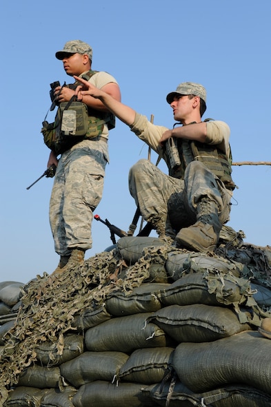 KUNSAN AIR BASE, Republic of Korea -- Senior Airmans Johnattan Martinez, left, and Trevor Seymour, 8th Security Forces Squadron augmentees, scan their assigned sector for suspicious activity during exercise Beverly Midnight 13-3, Aug. 8, 2013. Spotting and reporting activities is a tiring, yet vital part of maintaining the base’s defense. (U.S. Air Force photo by Staff Sgt. Tong Duong/ Released.)