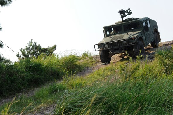 KUNSAN AIR BASE, Republic of Korea -- Senior Airman Kevin Rozas, driver, and Airman 1st Class Daniel Pryor, 8th Security Forces Squadron patrolmen, navigate down from Little Coyote Hill during exercise Beverly Midnight 13-3, Aug. 8, 2013. Patrol vehicles check in on defensive fighting position defenders to replenish water and supplies. (U.S. Air Force photo by Staff Sgt. Tong Duong/ Released.)