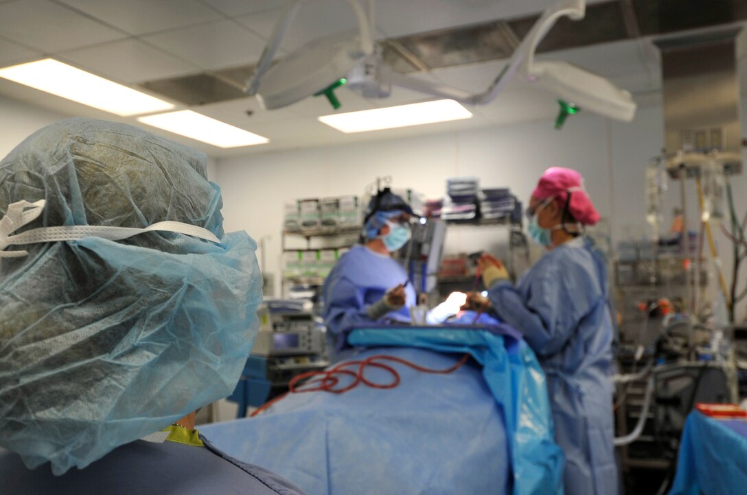 Major Jamie Swartz, an ear nose and throat surgeon, and her assistant, Staff Sgt. Robyn Wilcox, perform an open septorhinoplasty on a patient in the Craig Joint Theater Hospital on Bagram Airfield, Afghanistan, July 22, 2013. The procedure performed separated his nose into a left and right side straightening the septum and bones, reducing the obstruction and allowing the patient to breathe better. The patient had problems breathing, headaches and pressure because of an obstruction inside his nose. (U.S. Air Force photo/Staff Sgt. Stephenie Wade)