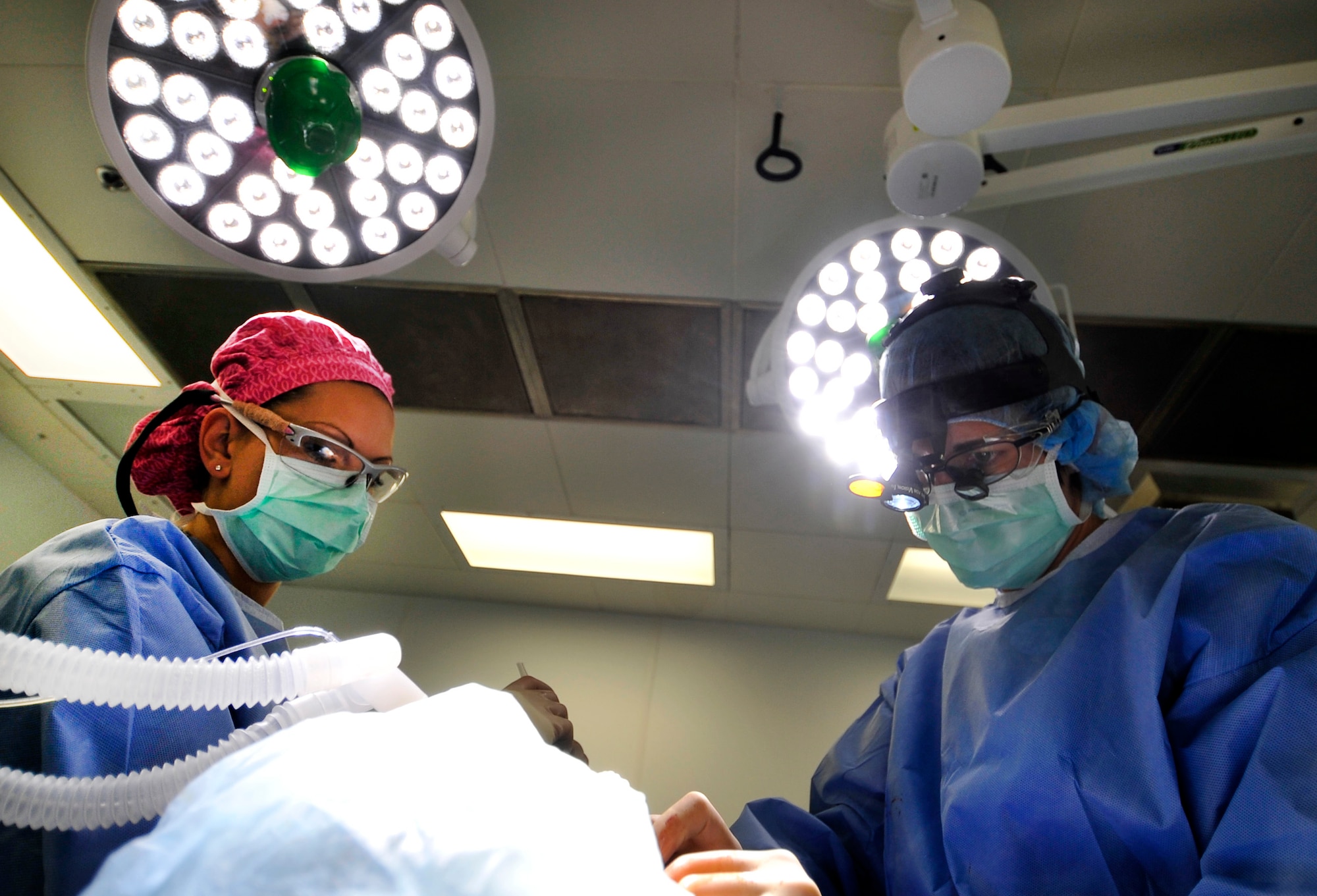 Major Jamie Swartz, an ear nose and throat surgeon, and her assistant, Staff Sgt. Robyn Wilcox, perform an open septorhinoplasty on a patient in the Craig Joint Theater Hospital on Bagram Airfield, Afghanistan, July 22, 2013. The procedure performed separated his nose into a left and right side straightening the septum and bones, reducing the obstruction and allowing the patient to breathe better. The patient had problems breathing, headaches and pressure because of an obstruction inside his nose. (U.S. Air Force photo/Staff Sgt. Stephenie Wade)