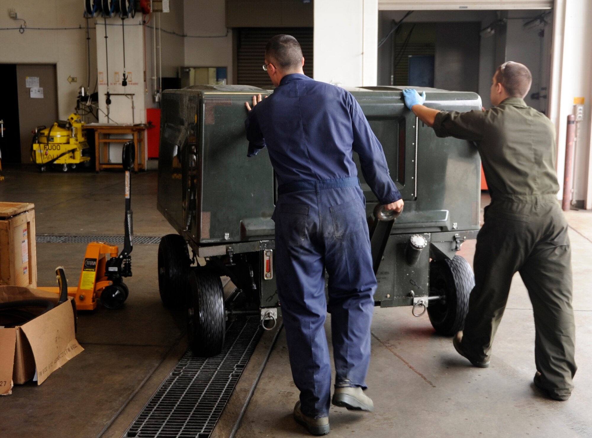 U.S. Air Force Staff Sgt. Brian McKinley, left, and Airman 1st Class Colton Bair, 35th Maintenance Squadron Aerospace Ground Equipment members, relocate a generator after cleaning it as part of a phase-two periodic inspection at Misawa Air Base, Japan, Aug. 8, 2013. Phase-one inspections are done every six months, and include changing air filters, changing oil and replacing wheel bearings. The phase-two periodic inspections are done every 12 months, and are more complicated and in-depth than phase-one inspections. (U.S. Air Force photo by Airman 1st Class Kaleb Snay)