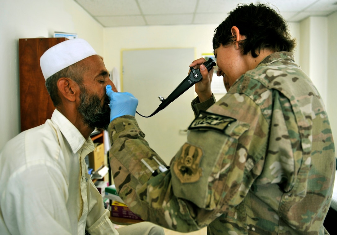 Major Jamie Swartz, an ear, nose and throat surgeon assigned to the 455th Expeditionary Medical Group, inserts a flexible laryngoscope through a patient’s nose to examine his throat and vocal cords at the Korean humanitarian Hospital on Bagram Airfield, Afghanistan, July 30, 2013. The patient was complaining of a sore throat. (U.S. Air Force photo/Staff Sgt. Stephenie Wade)