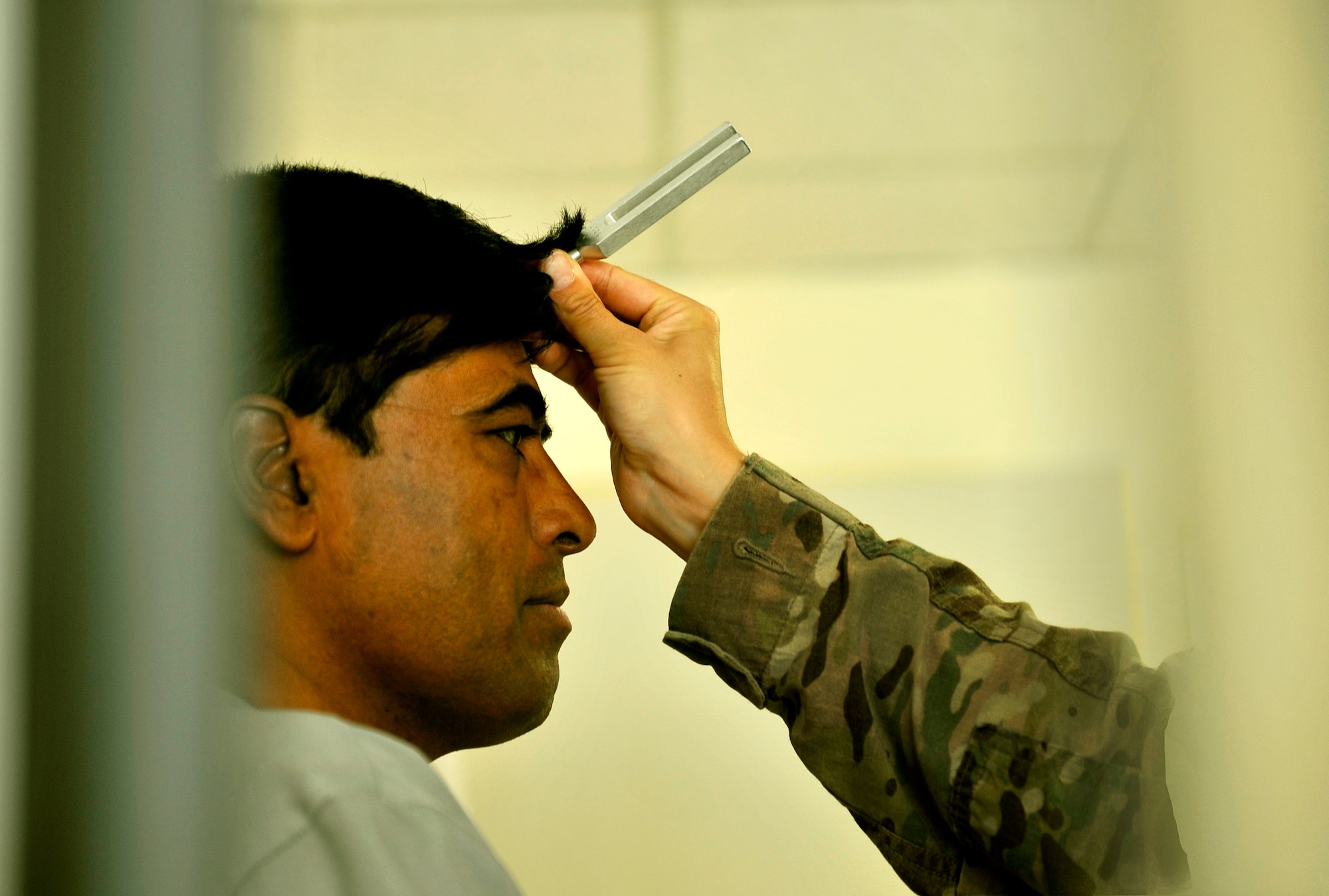 Staff Sgt. Robyn Wilcox, 455th Expeditionary Medical Group ear, nose and throat clinic technician, uses a vibrating tuning fork to test a patient’s hearing at the Korean humanitarian Hospital on Bagram Airfield, Afghanistan, July 30, 2013. The patient was complaining of hearing loss in the right ear. Wilcox is deployed from Lackland Air Force Base, Texas. (U.S. Air Force photo/Staff Sgt. Stephenie Wade)