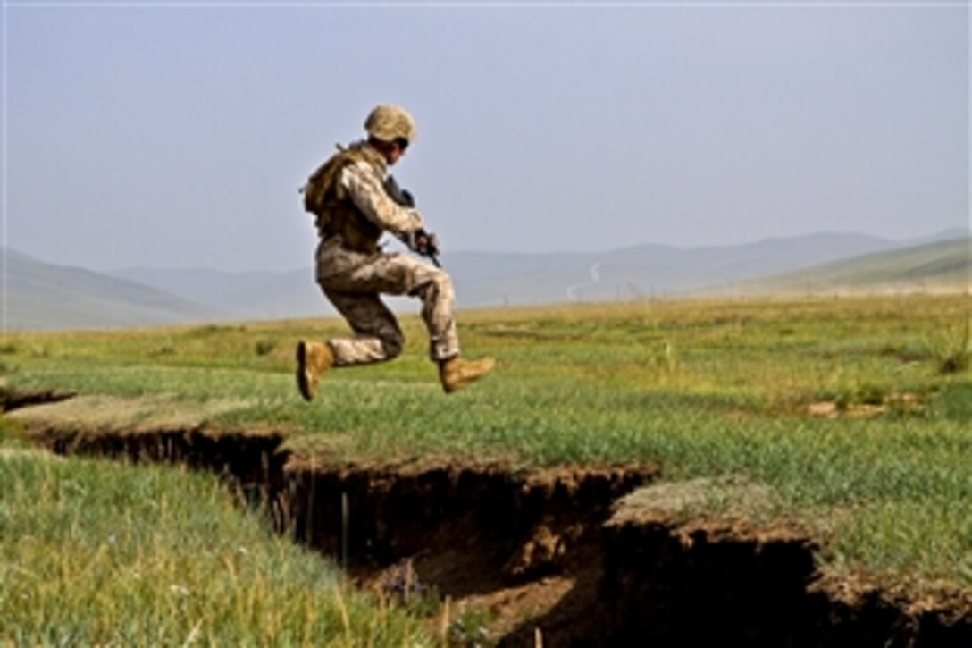 U.S. Marine Lance Cpl. Nicholas Moore jumps over a ditch during a cordon and search event during Khaan Quest 2013 at Five Hills Training Area in Mongolia, Aug. 08, 2013. Moore is assigned to the 3rd Marine Division's 3rd Battalion, 3rd Marine Regiment. The United States and Mongolia sponsor the annual exercise to strengthen the capabilities of U.S., Mongolian and other forces in international peace support operations.