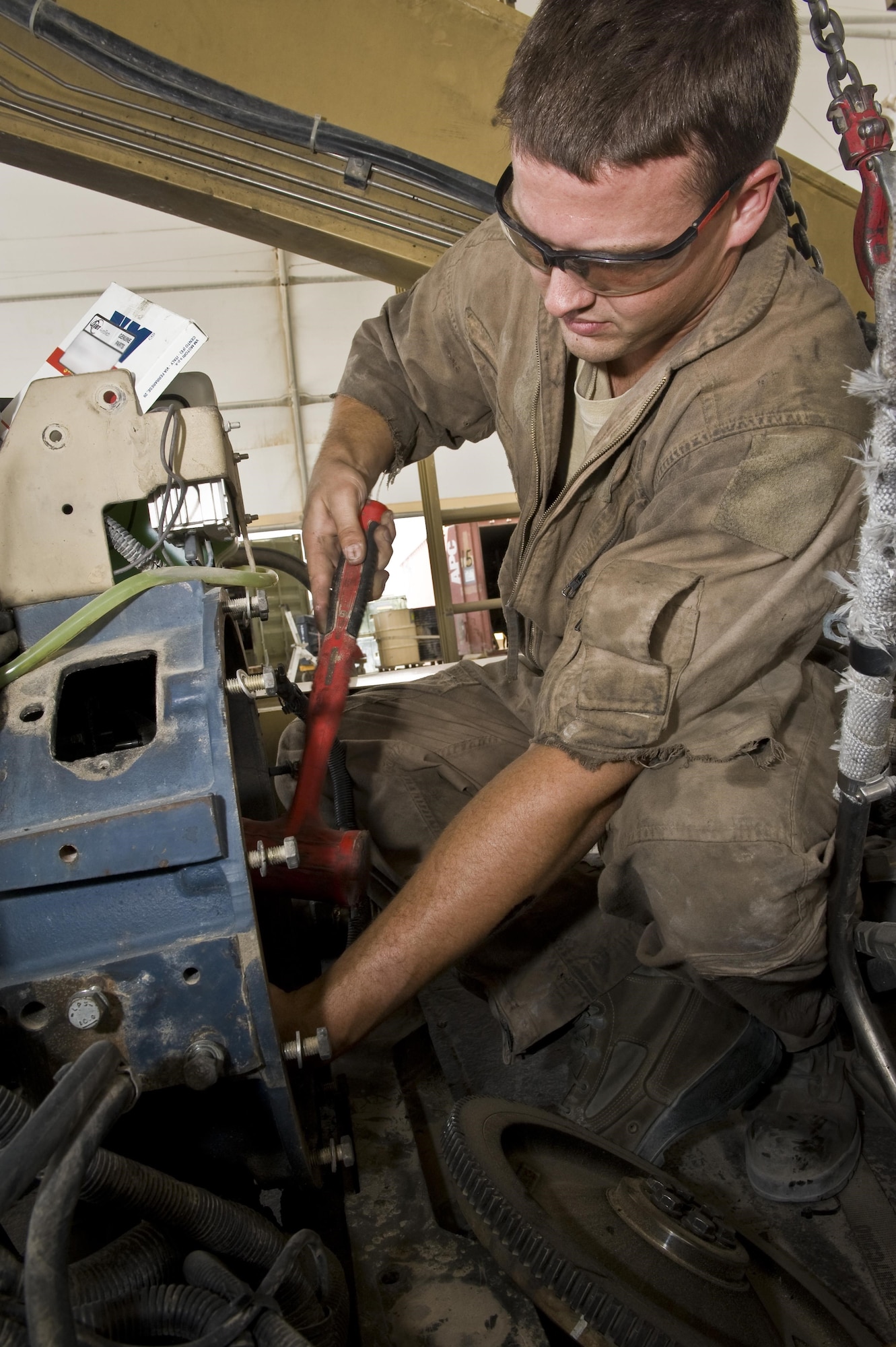 Airman 1st Class Tyler Jones performs routine maintenance on an aircraft cargo loader July 31, 2013, at the 379th Air Expeditionary Wing in Southwest Asia. Jones is a 379th Expeditionary Logistics Readiness Squadron vehicle mechanic deployed from Eielson Air Force Base, Alaska.