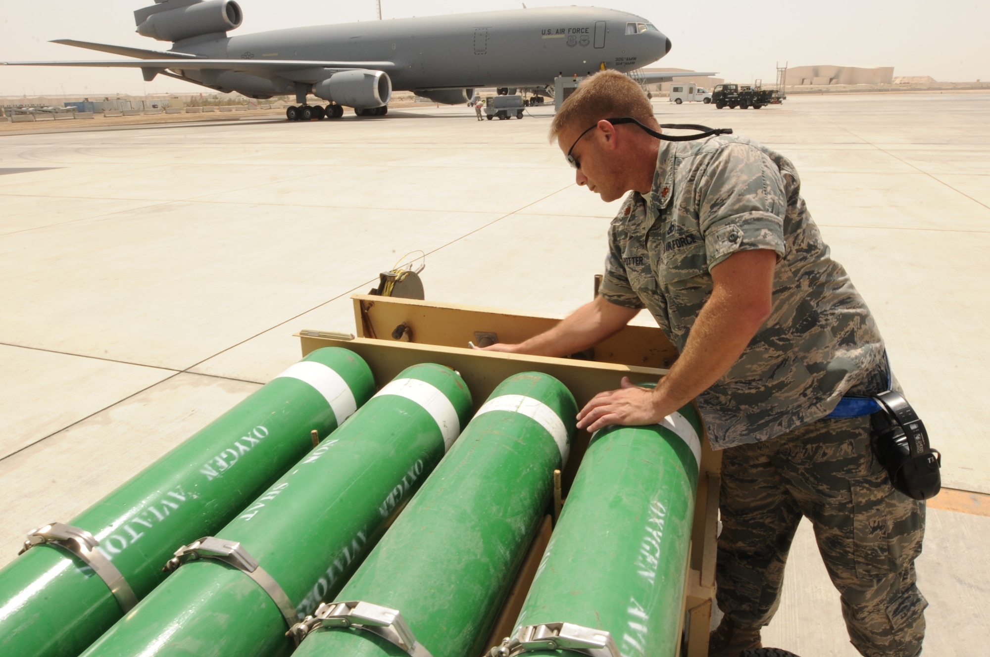 U.S. Air Force Major Thomas Potter, 380th Expeditionary Aircraft Maintenance Squadron KC-10 Aircraft Maintenance Unit officer in charge, inspects oxygen tanks used to fill oxygen systems on the KC-10 Extender at an undisclosed location in Southwest Asia Aug. 5, 2013. Potter inspects the oxygen tanks to make sure they are full. Potter calls Latrobe, Calif., home and is deployed from Travis Air Force Base, Calif. (U.S. Air Force photo by Staff Sgt. Jacob Morgan)