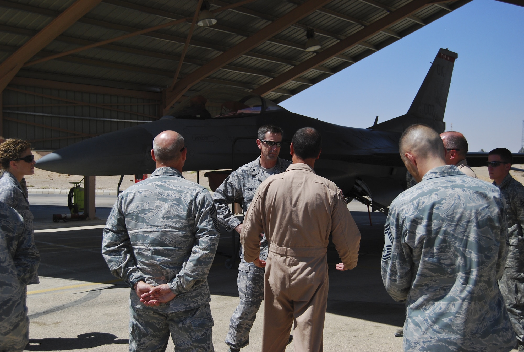 U.S. Air Force Brig. Gen. Kevin Schneider, middle, 380th Air Expeditionary Wing commander, stands in front of an F-16 Fighting Falcon operated by the 407th Air Expeditionary Group at an undisclosed location in Southwest Asia Aug. 2, 2013. Schneider, along with the command chief and other staff agency chiefs visited the three geographically separated units under the 380th AEW, which support Operation Enduring Freedom and Joint Task Force Horn of Africa. (U.S. Air Force photo by Tech. Sgt. Adonis Cabarle)