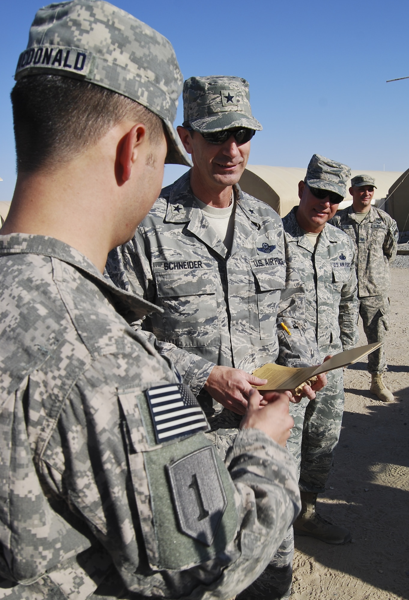 U.S. Air Force Brig. Gen. Kevin Schneider, middle, 380th Air Expeditionary Wing commander, and U.S. Air Force Chief Master Sgt. Garth Meade, right, are given a tour of the facilities and equipment operated by the 82nd Expeditionary Air Support Operations Squadron at an undisclosed location in Southwest Asia Aug. 1, 2013. Schneider, along with the command chief and other staff agency chiefs visited the three geographically separated units under the 380th AEW, which support Operation Enduring Freedom and Joint Task Force Horn of Africa. (U.S. Air Force photo by Tech. Sgt. Adonis Cabarle)