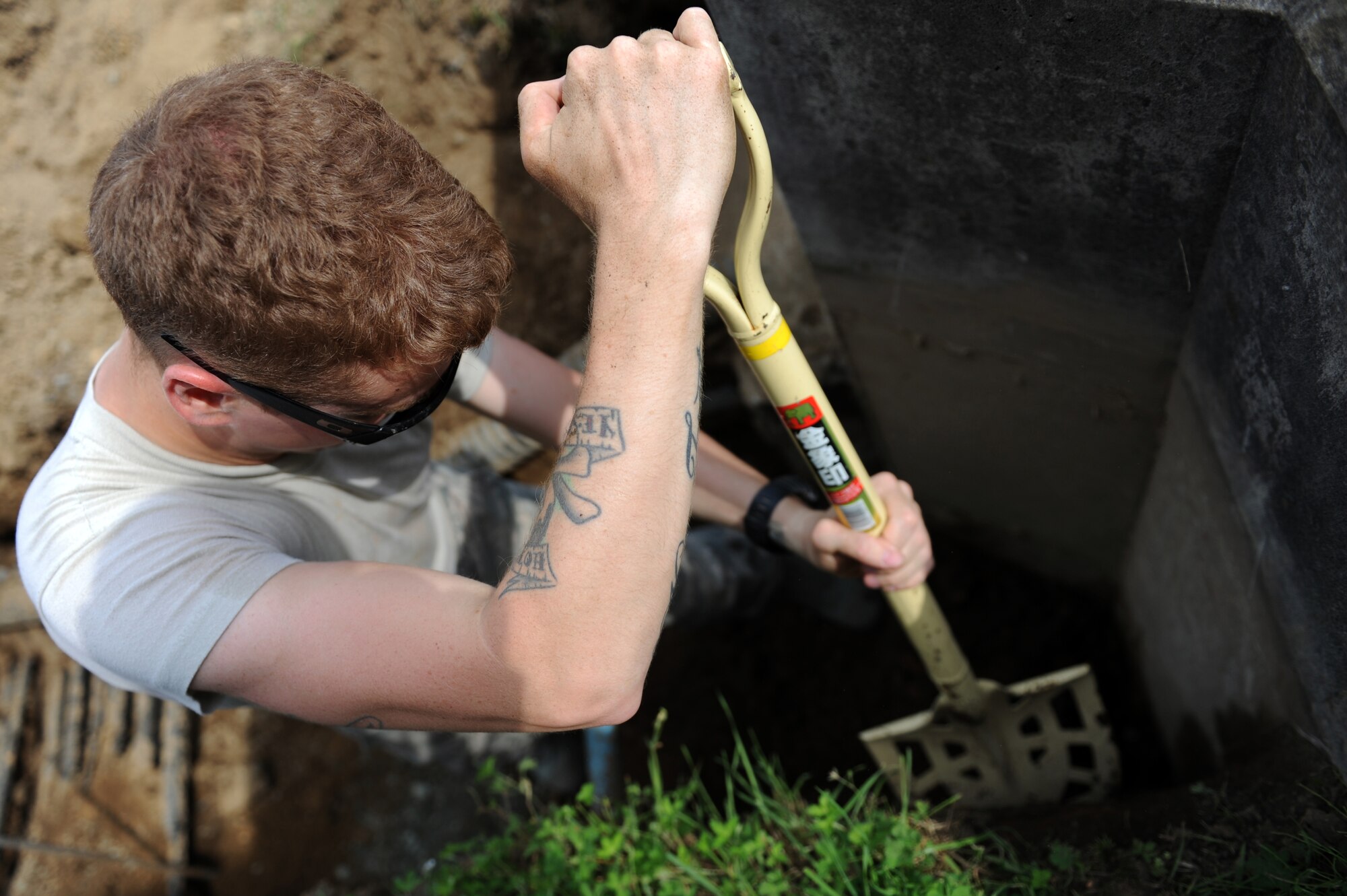 U.S. Air Force Senior Airman Hunter Stom, 35th Civil Engineer Squadron structural journeyman, clears dirt to make room for a core drill at Misawa Air Base, Japan, Aug. 8, 2013. Stom used the core drill to help with the installation of a base-wide internet upgrade scheduled to take place between Oct. 1 and March 31, 2014. (U.S. Air Force photo by Senior Airman Kia Atkins)