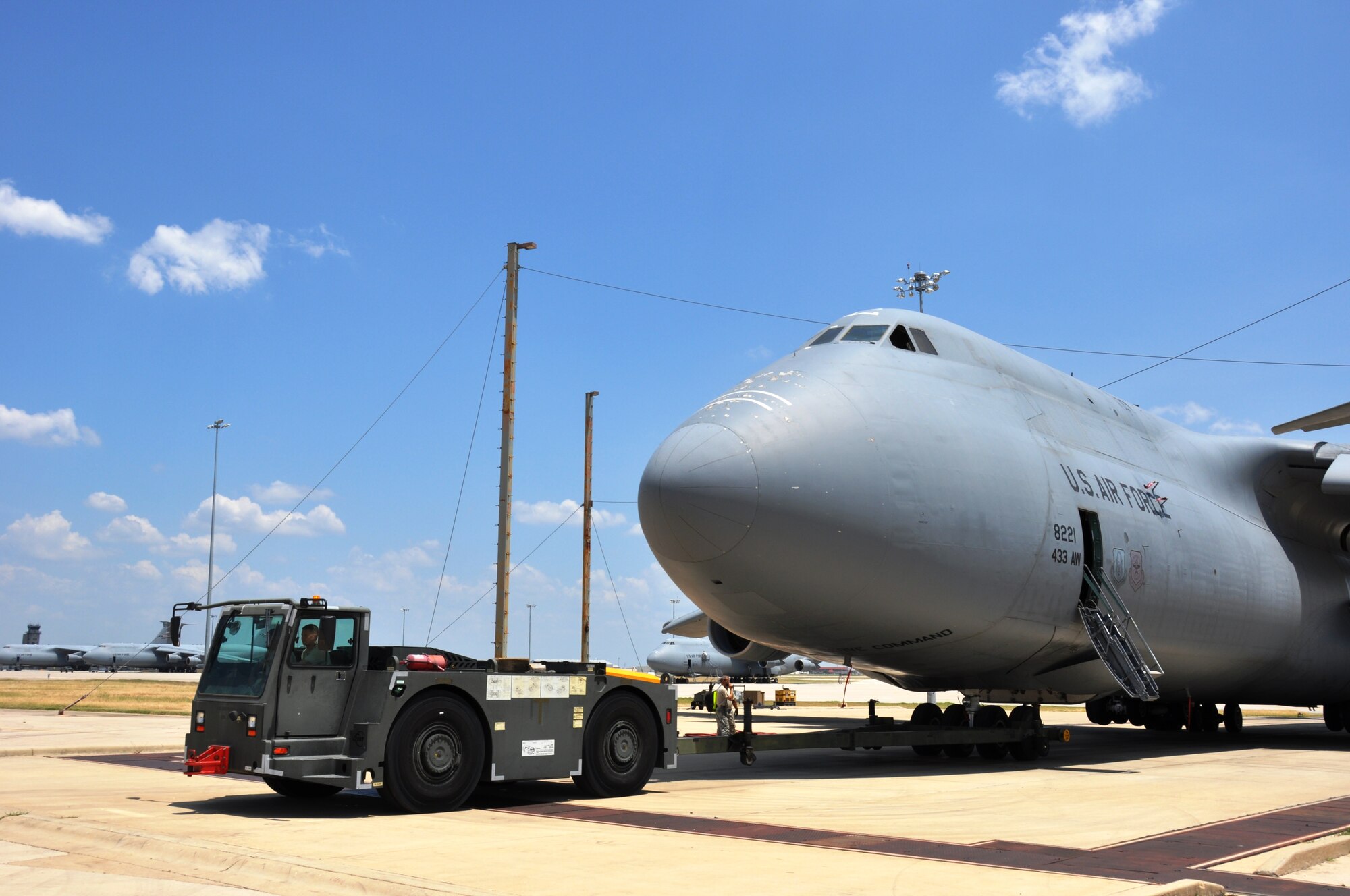 Crew chiefs from the 433rd Aircraft Maintenance Squardon tow a C-5A Galaxy on the flight line into the wash rack here Aug 10.  Temperatures on the flight line are 15-20 degrees higher than what is reported by weather information sites. According to the Airman’s Manual, “Heat can be incapacitating or deadly.” The manual says frequent hydrating is necessary when exercising or working. (U.S. Air Force photo by Tech Sgt. Carlos J. Trevino)

