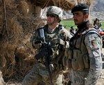 U.S. Army Cpt. Derek C. Knapp, of Austin, Texas, with Security Force Assistance Team 10, Texas Army National Guard, and his Afghan Border Police counterpart discuss security during a shura near the area known as the "Jungle" during Operation Southern Fist III March 5.