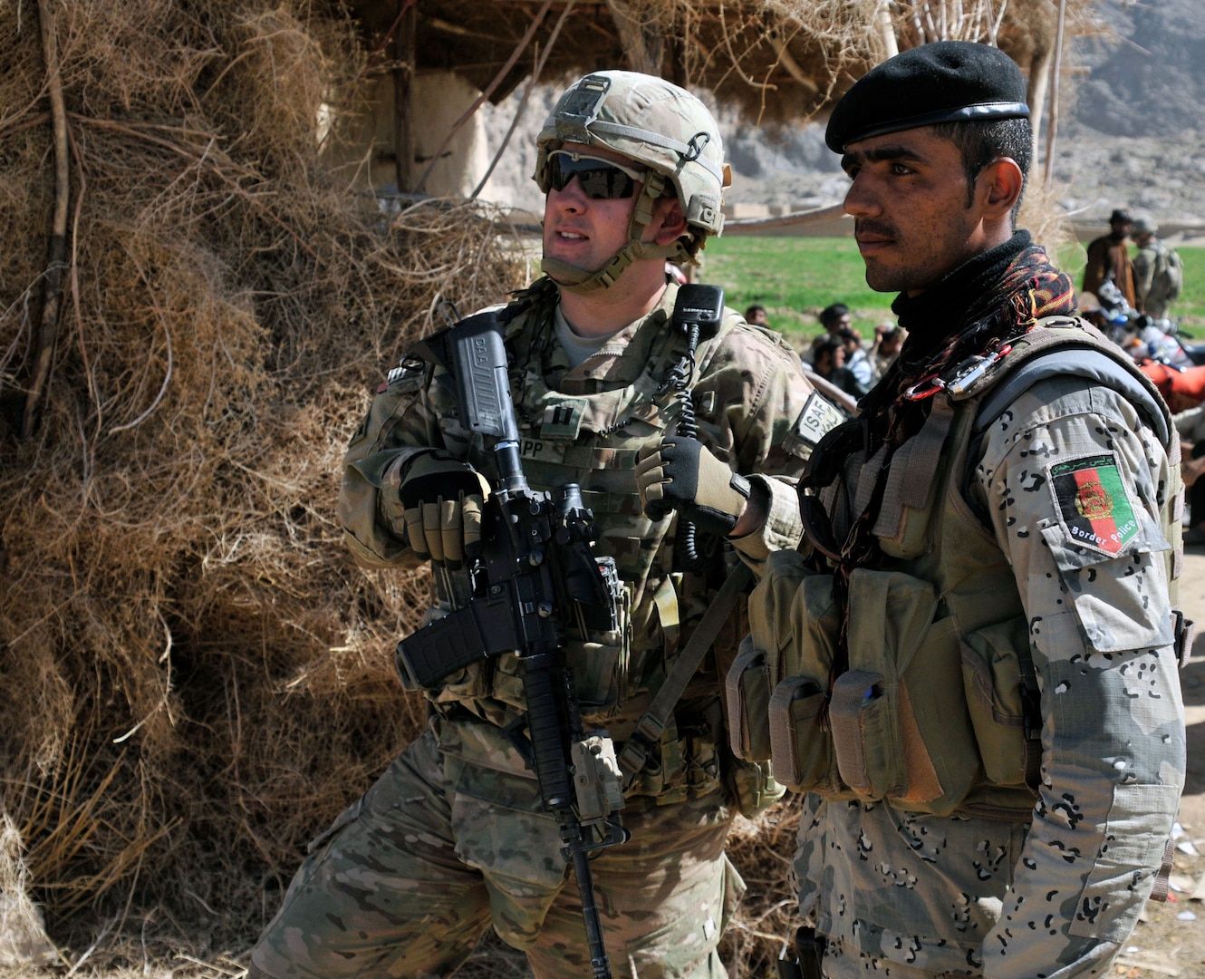 U.S. Army Cpt. Derek C. Knapp, of Austin, Texas, with Security Force Assistance Team 10, Texas Army National Guard, and his Afghan Border Police counterpart discuss security during a shura near the area known as the "Jungle" during Operation Southern Fist III March 5.