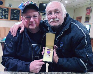 Sgt. 1st Class Alan Foss, of the Wisconsin Army National Guard, and Ralph Brandenburg, commander of Klubertanz-Trapp VFW Post 9362 in Sun Prairie, Wis., pose with Staff Sgt. Otto A. Trapp's Purple Heart Feb. 28. The VFW post is named in honor of Trapp, who was killed in action in 1944.