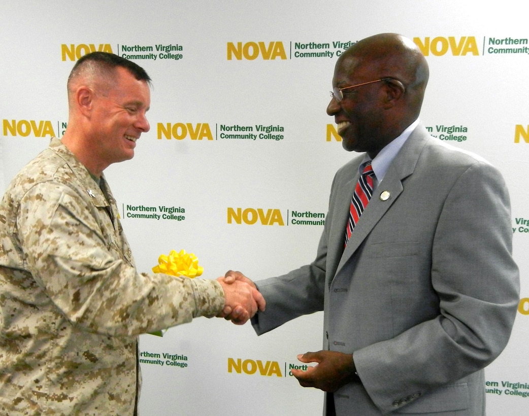 Col. David W. Maxwell, Marine Corps Base Quantico commander, shakes hands and thanks, Sam Hill, Northern Virginia Community College provost, July 29, 2013, for NOVA’s efforts to reach the military academic community at the Voluntary Education Center of aboard Marine Corps Base Quantico. NOVA revamped their business administration and information systems technology program, making the them shorter. 