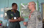Cameroon Army 1st Lt. Eseye E. Sako discusses Central Accord 2013 with Capt. Gary Ripplinger of the North Dakota Army National Guard, Feb. 23, 2013, at Cameroon Air Force Base, Douala, Cameroon.