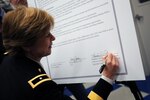 Army Brig. Gen. Marianne Watson, the director of Manpower and Personnel at the National Guard Bureau, signs the agreement between the NGB and the Corporation for National Community Service March 13, 2013, in Wilmington, Del., for the NGB Joining Community Forces initiative. The new initiative is a community level, grass roots solution program that expands on the Joining Forces campaign of first lady Michelle Obama and Dr. Jill Biden. JCF focuses on supporting all service members, families, and veterans in the areas of employment, education, across all components.
