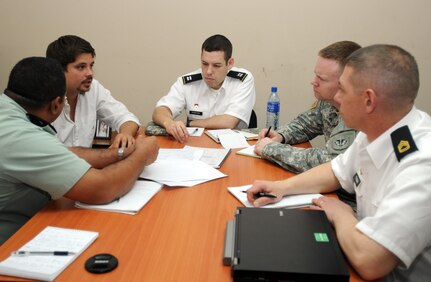 The Military Engagement Team's operations section, including Capt. Joshua Porter, middle, Sgt. 1st Class Culley Popma and Sgt. 1st Class John Tynan, right, discuss contingency plans with Maj. Aldo Mendieta, left, civil defense first officer for plans and operations, March 11, 2013.