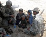 Army Staff Sgt. Mangnan Tan, a medic from Lubbock, Texas, with Security Force Assistance Team 10, Texas Army National Guard, treats a child who approached his unit near an area known as the "Jungle" during Operation Southern Fist III, March 6, 2013, in Afghanistan.