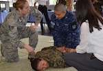 Staff Sgt. Autumn Clark instructs a member of the Salvadoran Air Force on the techniques to subdue and restrain a suspect, played here by a classmate from the Salvadoran army.