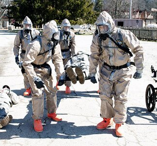 Members of the Kentucky Chemical, Biological, Radiological, Nuclear and High Yield Explosive Enhanced Response Force Package decontamination element transport a mock victim for medical assessment during training at Muscatatuck Urban Training Center in Butlerville, Ind., March 22, 2013.