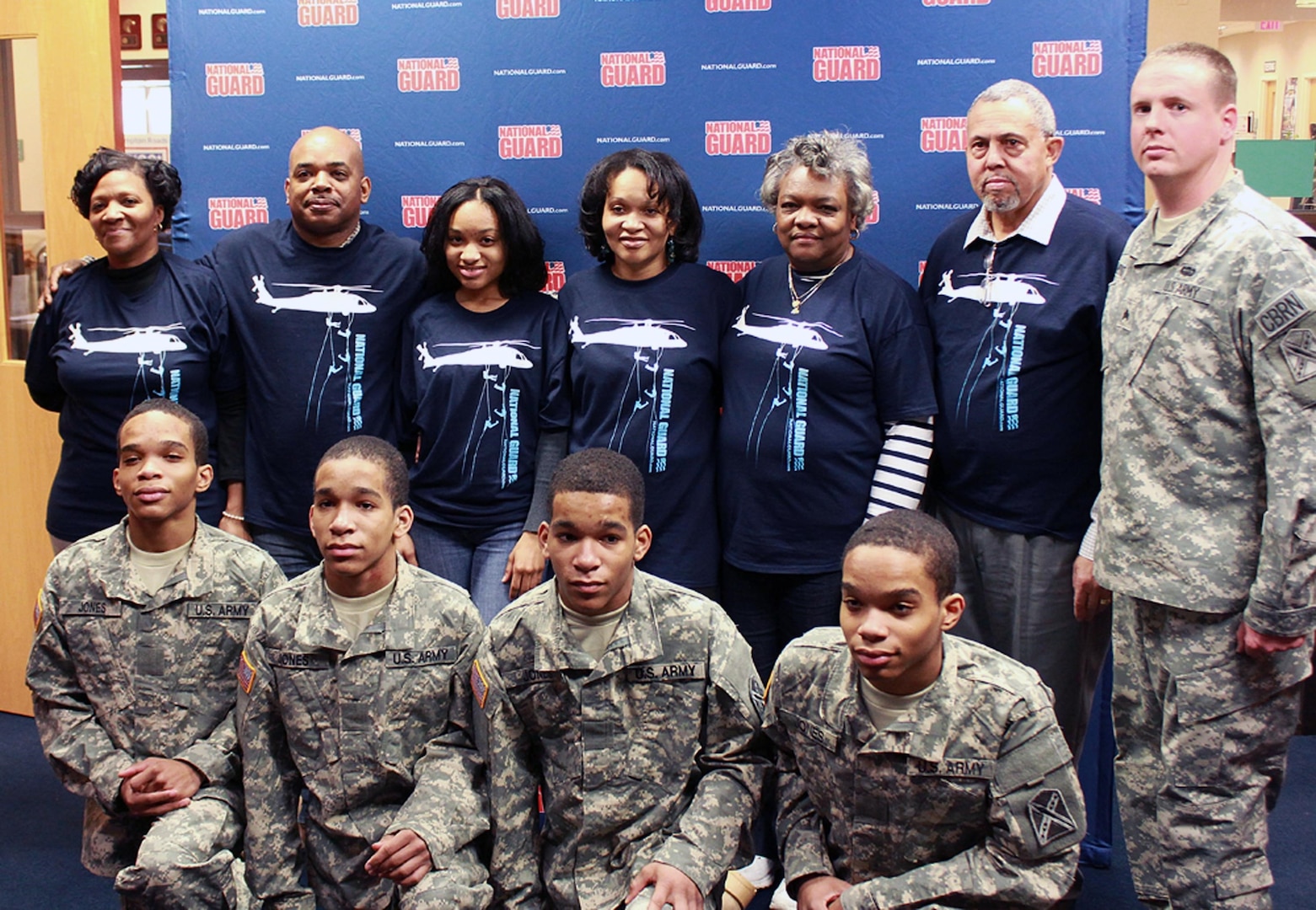 Kahlil, Karon, Kameron and Karlyle Jones pose with family and friends after their enlistment March 7, 2013, at Fort Lee, Va. Sgt. Brian Merritt (far right) was their recruiter.