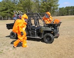 Two members of the North Carolina National Guard's 42nd Civil Support Team's survey section prepare for transport on a Polaris quad track vehicle to a simulated Chemical, Biological, Radiological, Nuclear and of Explosive (CBRNE) incident site during the unit's evaluation March 28, 2013.