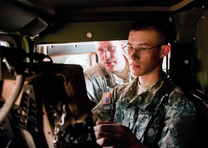 Sgt. 1st Class Mitchell Patzel and Pvt. Mitchell Patzel, Jr. work on a Movement Tracking System in a truck in El Salvador April 5, 2013. The father-son duo are there for training.