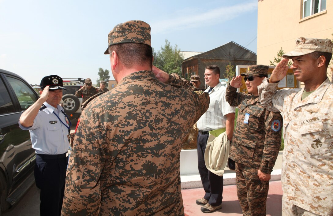Col. Hector Velez (right), U.S. exercise director for Khaan Quest 2013, and Mongolian Armed Forces Col. B. Baatar (center), commanding officer of Tavan Tolgoi (Five Hills) Training Area, greet Gen. Shigeru Iwasaki, Chief of the Joint Staff for the Japan Self Defense Forces and Japan's top uniformed military official, during his visit to Five Hills Training Area, Aug. 8. Khaan Quest is a peacekeeping operations-focused, combined training event between U.S. Marine Corps Forces Pacific, U.S. Army Pacific, and the MAF. MARFORPAC and USARPAC have conducted similar training with MAF since 2003, and this exercise marks the 11th iteration of Khaan Quest. Military personnel from Australia, Canada, France, Germany, Japan, India, Nepal, Republic of Korea, Tajikistan, United Kingdom and Vietnam are also participating in the exercise.