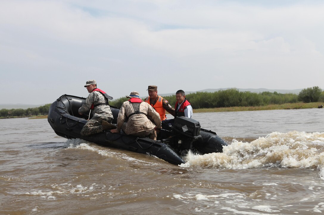 (From right) Gen. Shigeru Iwasaki, Chief of the Joint Staff for the Japan Self Defense Forces and Japan's top uniformed military official, and Mongolian Armed Forces Col. B. Baatar, commanding officer of Tavan Tolgoi (Five Hills) Training Area, take a ride in a Zodiac inflatable boat during Iwasaki's visit to Five Hills Training Area, Aug. 8. The boat was piloted by Lance Cpl. Gregory Patterson, Alpha Company, 9th Engineer Support Battalion out of Okinawa Japan, and U.S. Army Staff Sgt. Colin Oppeguard, a member of the 1-297th Reconnaissance and Surveillance Battalion, Alaska Army National Guard. Khaan Quest is a peacekeeping operations-focused, combined training event between U.S. Marine Corps Forces Pacific, U.S. Army Pacific, and the MAF. MARFORPAC and USARPAC have conducted similar training with MAF since 2003, and this exercise marks the 11th iteration of Khaan Quest. Military personnel from Australia, Canada, France, Germany, Japan, India, Nepal, Republic of Korea, Tajikistan, United Kingdom and Vietnam are also participating in the exercise. 