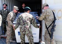 Sgt. Maj. David Munden, Kentucky Agribusiness Development Team noncommissioned officer in charge and Sgt. Eric Schenck, 1st Brigade, 1st Armored Division chaplain's assistant, help soldiers from the Afghan National Army with supplies at Forward Operating Base Pasab, Kandahar Province, March 17, 2013.