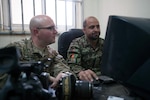 U.S. Army Spc. Ryan Scott, left, and Afghan National Army Staff Sgt. Sakhi Muhammed, a camera team noncommissioned officer, review Sakhi's photo products on Forward Operating Base Thunder, April 7, 2013.