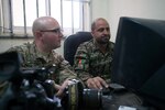 U.S. Army Spc. Ryan Scott, left, and Afghan National Army Staff Sgt. Sakhi Muhammed, a camera team noncommissioned officer, review Sakhi's photo products on Forward Operating Base Thunder, April 7, 2013.