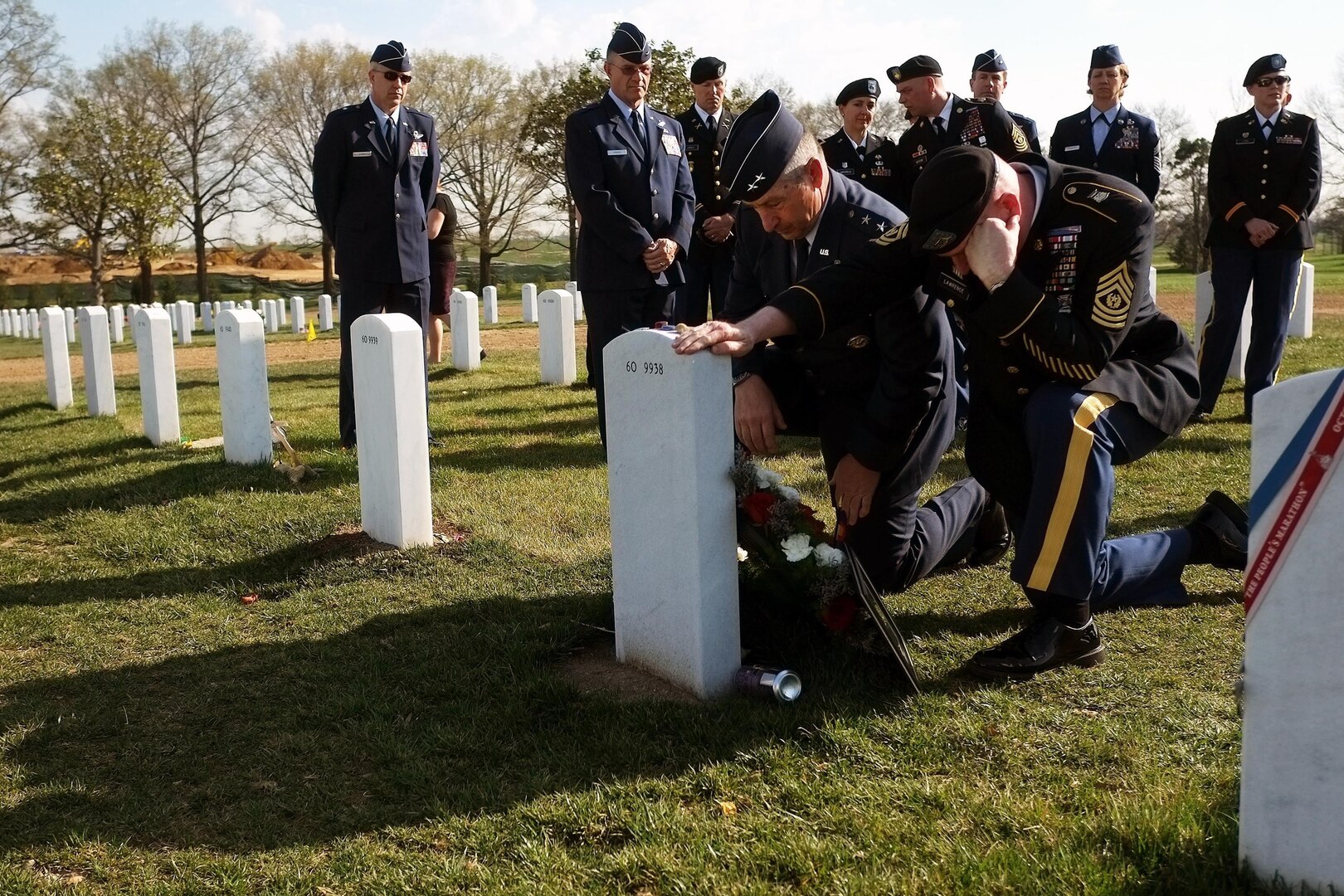 Air Force Maj. Gen. H. Michael Edwards, left, the adjutant general of the Colorado National Guard, and Command Sgt. Maj. Rob Lawrence, the senior enlisted leader to the adjutant general, pay their final respects at the headstone of crewmembers of Extortion 17 during a ceremony at Arlington National Cemetery, Wednesday, April 10, 2013.