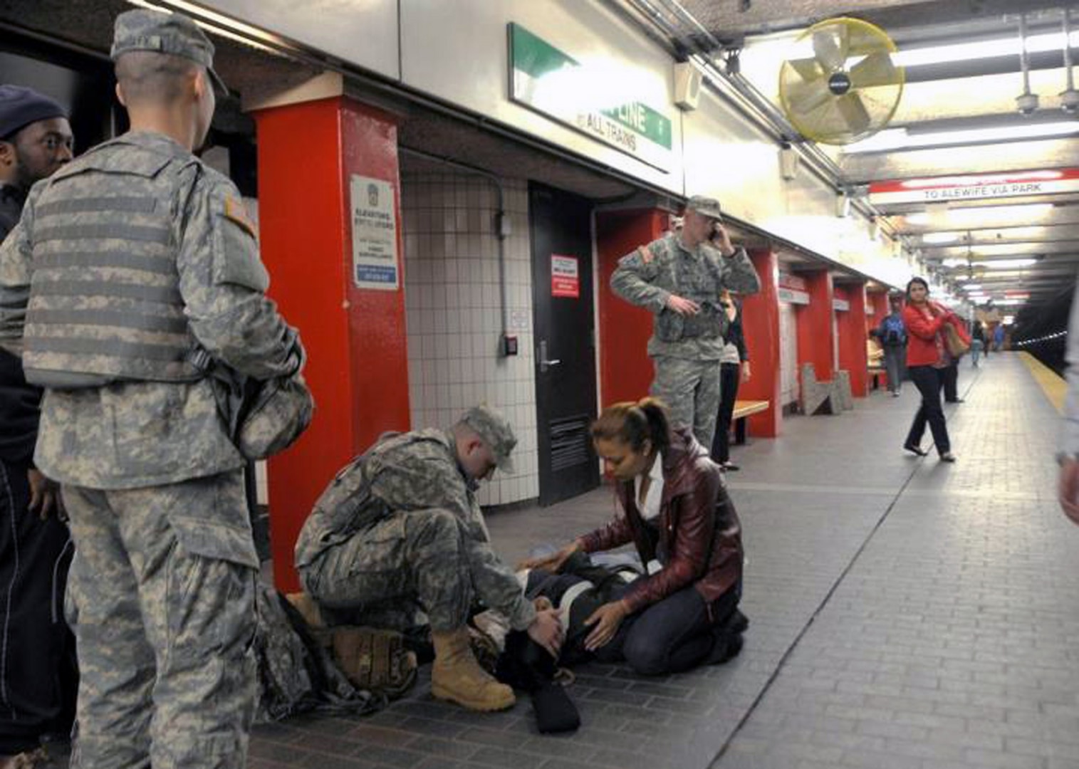 Spc. Christopher Abele assesses a woman who fainted at the Downtown Crossing train station in Boston, April 17, 2013. The Massachusetts National Guard has been assisting the Massachusetts Bay Transit Authority (MBTA) Police keep commuters safe in the aftermath of Monday's explosions.