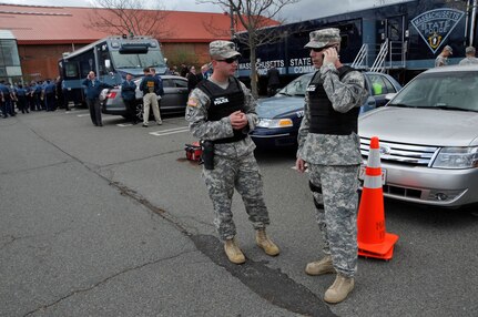 Capt. Tyler Field, commander, 747 Military Police Company, and Capt. Erik Filipe, Headquarters Detachment 211th Military Police Battalion, Massachusetts National Guard, support the search for the Marathon bombing suspect in Watertown Mass., April 19, 2013.