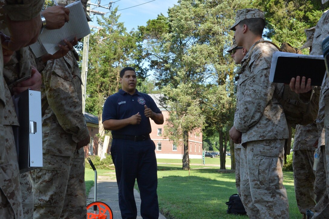 Leon Hughes, a firefighter with the Quantico Fire Department, explains some of the key issues they face at the firehouse to Marines from the Marine Corps Civil-Military Operations School during an infrastructure assessment exercise on Aug. 2, 2013, at Marine Corps Base Quantico. MCCMOS students are required to grasp the concepts taught at the schoolhouse prior to graduation.
