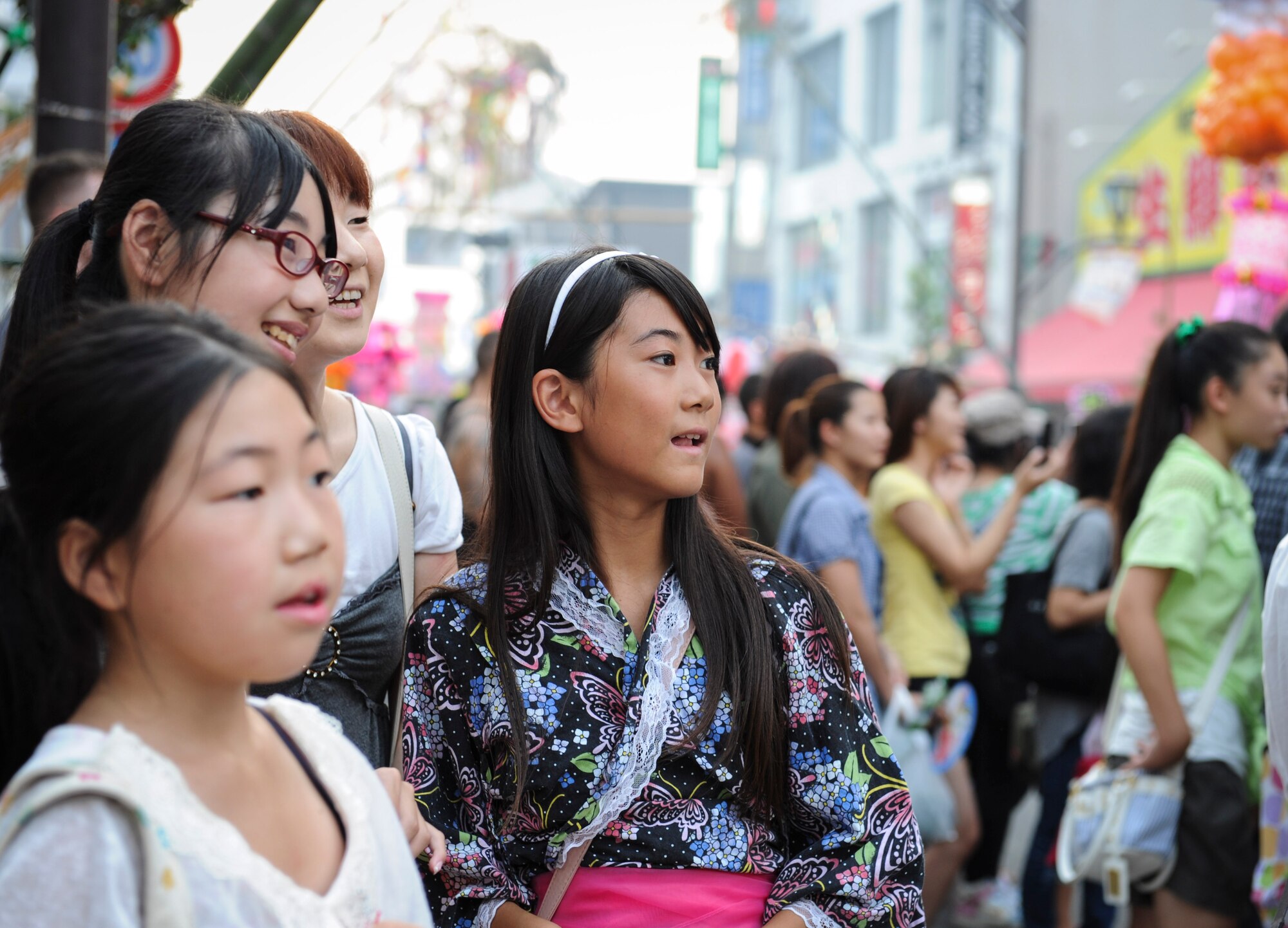 FUSSA CITY, Japan -- Japanese girls watch a parade with festival dancers at the Tanabata Festival in Fussa City, Japan, Aug. 9, 2013. The festival included several parades as well as street vendors selling a variety of traditional Japanese festival foods. (U.S. Air Force photo by Senior Airman Andrea Salazar/Released)