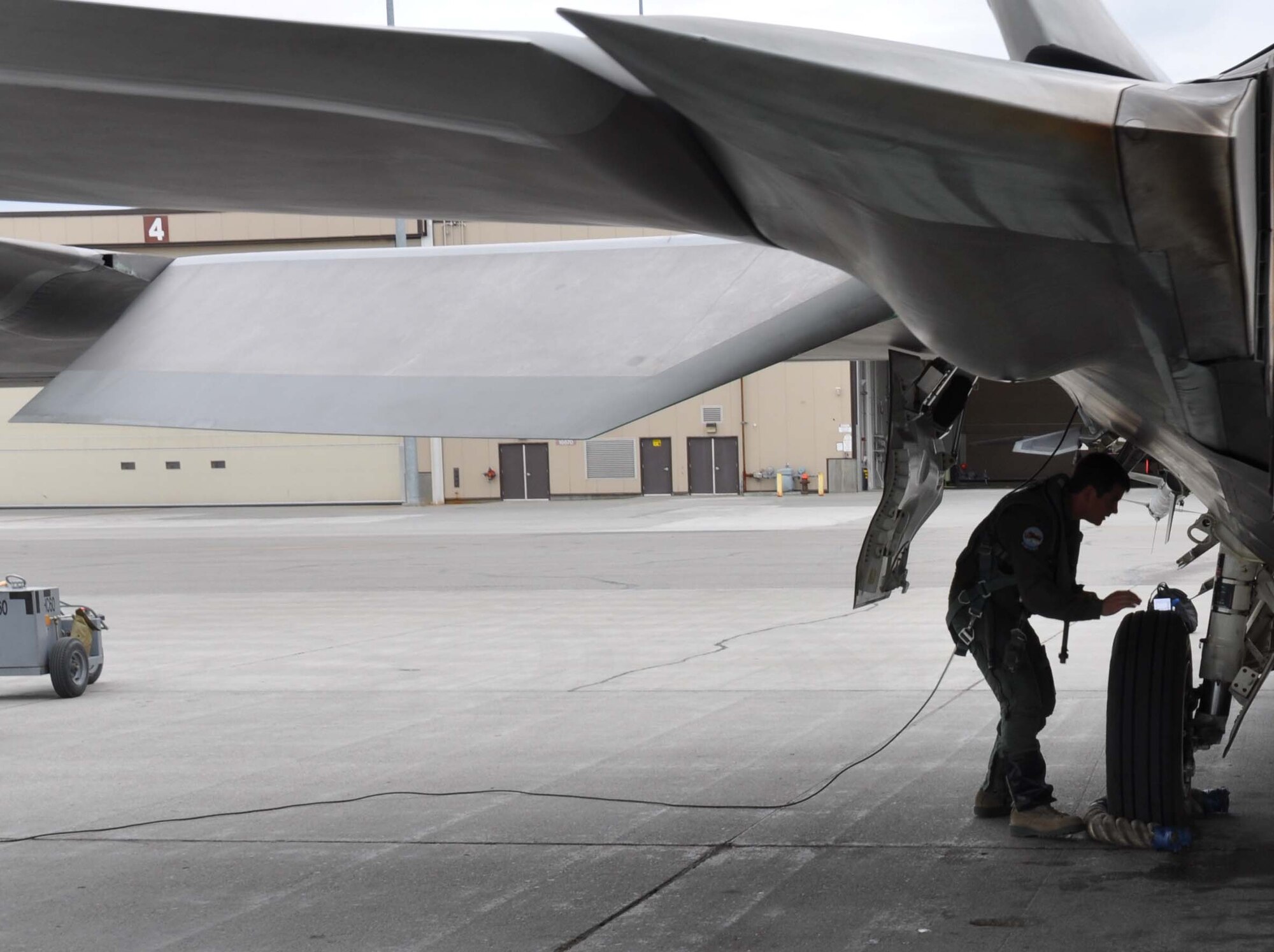 Maj. Wade Bridges, Reserve F-22 pilot assigned to the 302nd Fighter Squadron, conducts a pre-flight inspection of his F-22 here July 18. Bridges splits his time between flying the F-22 for Alaska’s only Air Force Reserve unit and a Boeing 737 for Alaska Airlines (U.S. Air Force/Capt. Ashley Conner)