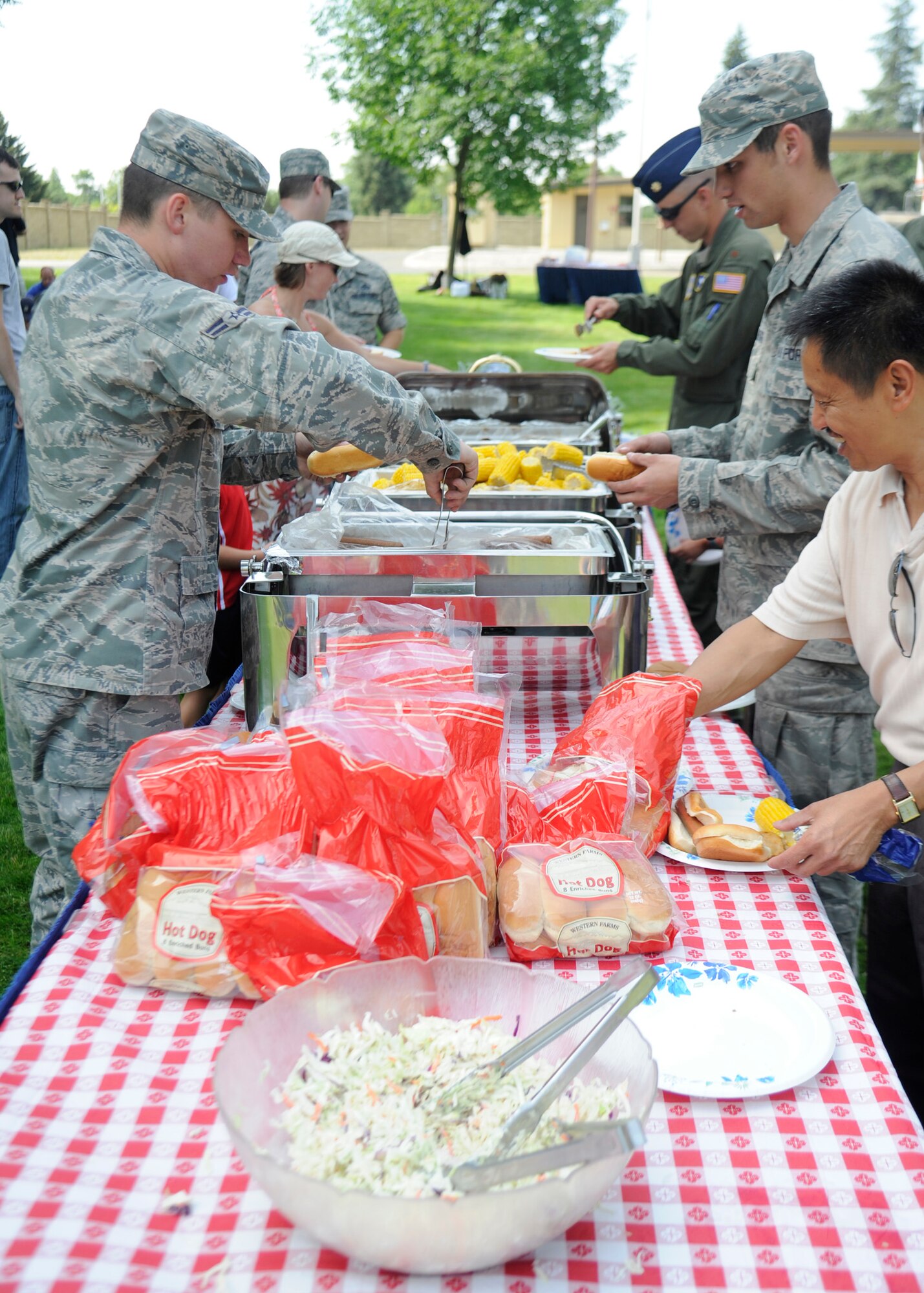 Members of Team Fairchild fill their plates in the food line during the base picnic at Fairchild Air Force Base, Wash., Aug. 9, 2013. Many foods were available including BBQ chicken, corn, pulled pork and hot dogs. (U.S. Air Force photo by Senior Airman Taylor Curry/Released)