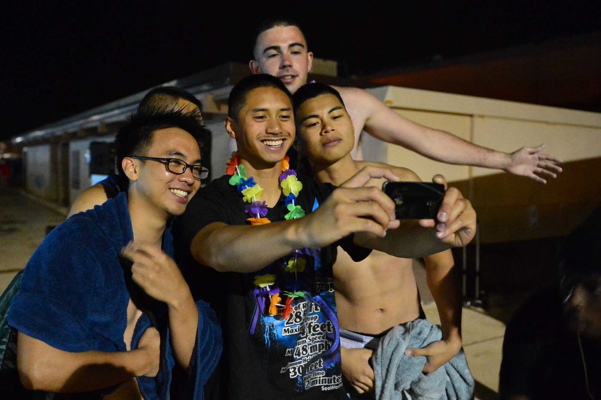 Airmen pose for a group cell phone picture at the DZ Pool during a pool party Aug. 10, 2013 at Cannon Air Force Base, N.M. The luau-themed party allowed them to partake in the aquatic center's features until almost midnight. (U.S. Air Force photo/ Airman 1st Class Eboni Reece)