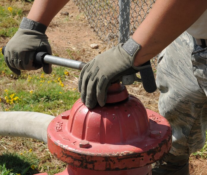 Senior Airman Marc Pacheco, 2nd Civil Engineer Squadron firefighter, opens a hydrant during a training exercise on Barksdale Air Force Base, La., Aug. 12, 2013. The hydrant was used to supply water to a well for firefighters to drain. (U.S. Air Force photo/Senior Airman Sean Martin)