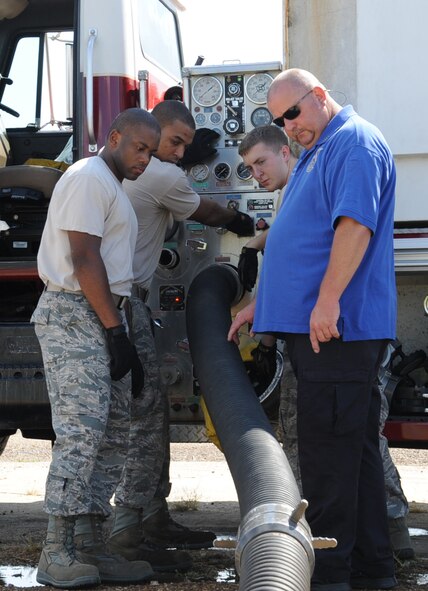 Airmen from the 2nd Civil Engineer Squadron Fire Department fill up a tanker truck on Barksdale Air Force Base, La., Aug. 12, 2013. The truck holds 5,000 gallons of water and is used as a water source for firefighters. (U.S. Air Force photo/Senior Airman Sean Martin)