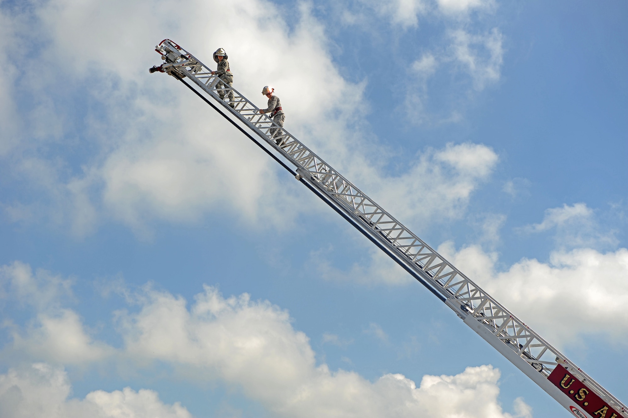 Master Sgt. Jennifer Roman, 375th Civil Engineer Squadron first sergeant, and Airman 1st Class Patrick Foy, 375th Civil Engineer firefighter, climbs the fire truck ladder Aug. 9, 2013 at Scott Air Force Base, Ill.  The ladder on the fire truck extends about 75 feet. (U.S. Air Force photo/Senior Airman Divine Cox)