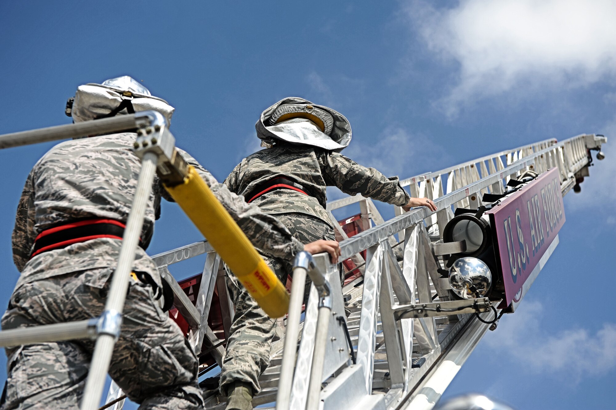 Master Sgt. Jennifer Roman, 375th Civil Engineer Squadron first sergeant, and Airman 1st Class Patrick Foy, 375th Civil Engineer firefighter, climbs the fire truck ladder Aug. 9, 2013 at Scott Air Force Base, Ill.  The ladder on the fire truck extends about 75 feet. (U.S. Air Force photo/Senior Airman Divine Cox)