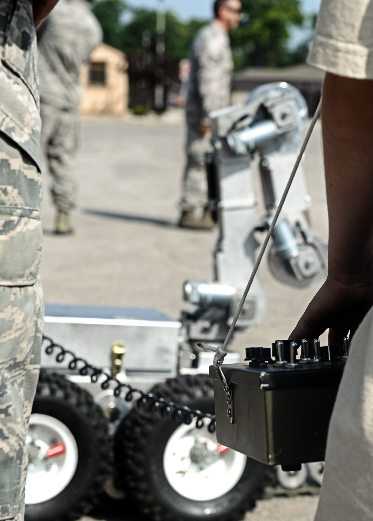 Senior Airman Joel Mixon, 375th Civil Engineer Squadron explosive ordinance disposal technician, watch Alex Bendele operate the EOD robot Aug. 9, 2013 at Scott Air Force Base, Ill.  The CES hosted a back to school event for Team Scott family members to come out, observe and play with som eof the equiptment used by CE. (U.S. Air Force photo/Senior Airman Divine Cox)