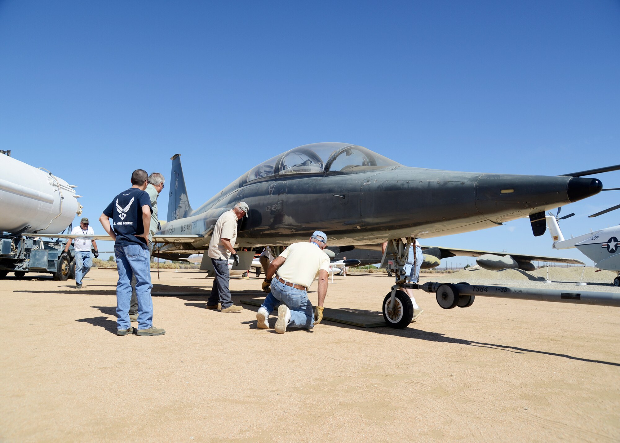 A crew of volunteers adjusts the position of the T-38A that was moved from the Air Force Flight Test museum’s restoration hangar 1864 Aug.9 to the museum's main display area. (U.S. Air Force photo by Rebecca Amber)