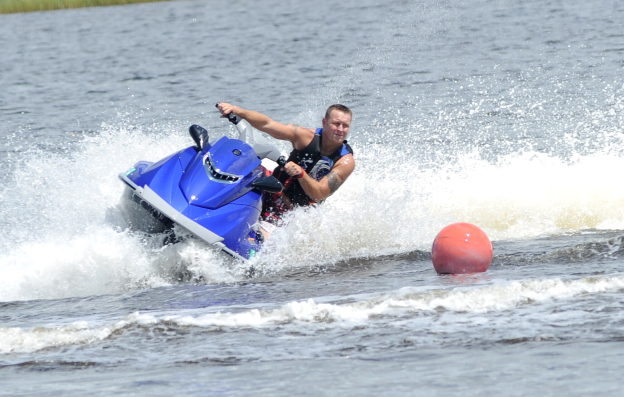 Tech. Sgt. Aaron Gaddis, 81st Security Forces Squadron, leans his jet ski as he makes his way around a buoy to complete the first of two races with a winning time of 44 seconds during a jet ski race in the Biloxi Back Bay behind Bayridge housing, at Keesler Air Force Base, Miss., Aug. 10, 2013.  There were 10 participants in the Keesler Outdoor Recreation sponsored event.  (U.S. Air Force photo by Kemberly Groue)