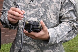 A Soldier tries out a Simple Key Loader (SKL), fielded by Project Director Communications Security, known as PD COMSEC, at Aberdeen Proving Ground, Md. PD COMSEC is in the process of replacing the SKL with a Next Generation Load Device, which will be nearly half the size and have more capabilities and features. (Courtesy Photo)